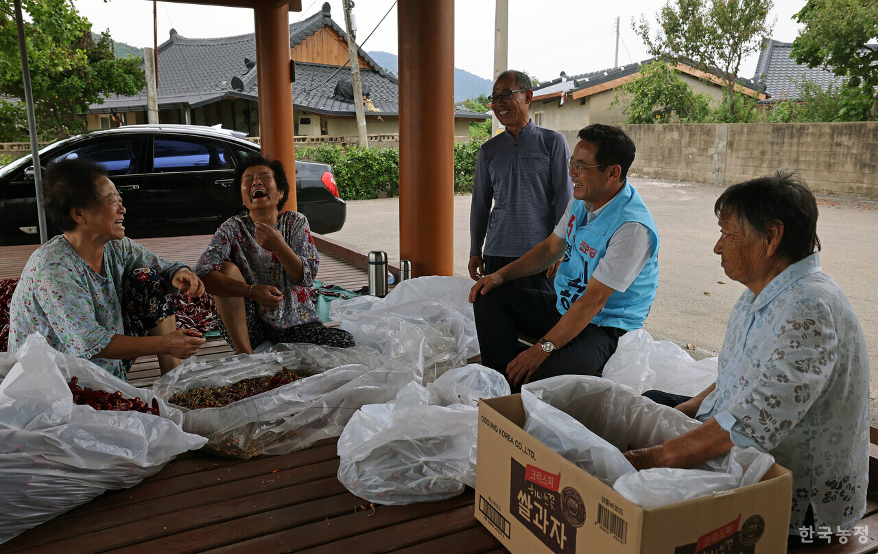 이석하 진보당 영광군수 후보가 지난 9월 2일 전남 영광군 백수읍 관내 경로당을 순회하던 중 마을 정자에서 건고추를 다듬던 주민들과 만나 담소를 나누며 밝게 웃고 있다. 한승호 기자