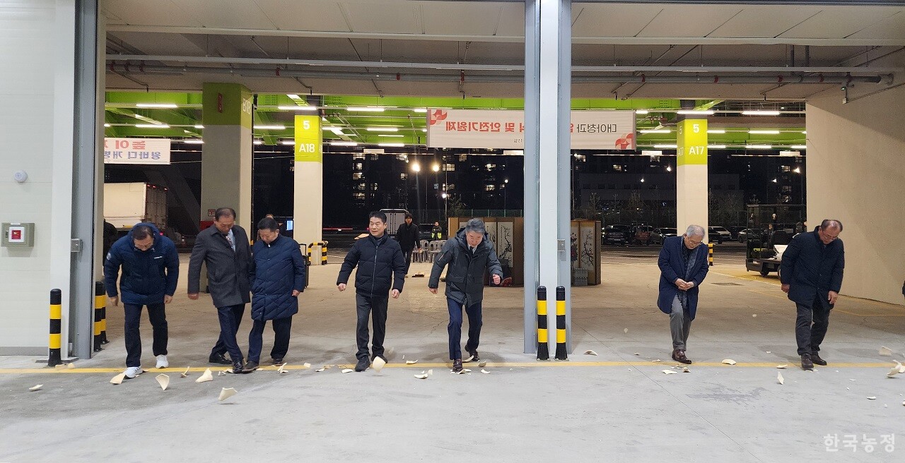 대아청과 입주기념식 및 안전기원제 이후 참석자들이 박을 깨며 채소2동 경매장에 들어서고 있다.