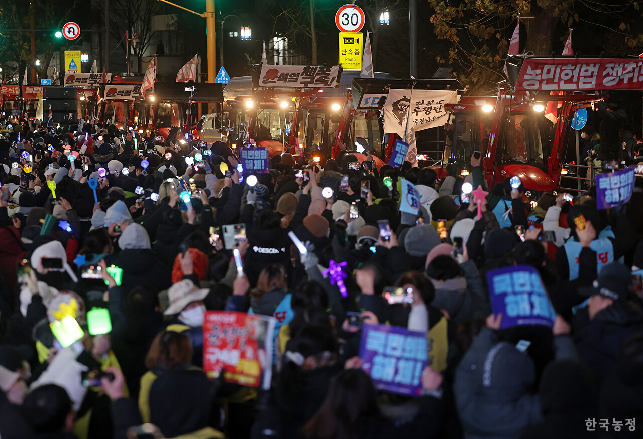 지난해 12월 22일 서울 서초구 남태령역 앞에서 열린 ‘내란수괴 윤석열 즉각 체포·구속! 농민 행진 보장 촉구 시민대회’에서 1박 2일 동안 끈질긴 저항 끝에 경찰의 차벽을 철수시키고 한남동 대통령 관저를 향해 다시 행진을 시작한 전봉준투쟁단 트랙터가 이날 저녁 한강진역 앞에서 열린 촛불집회장에 도착하자 1만여명의 시민들이 응원봉을 흔들며 환호하고 있다. 한승호 기자