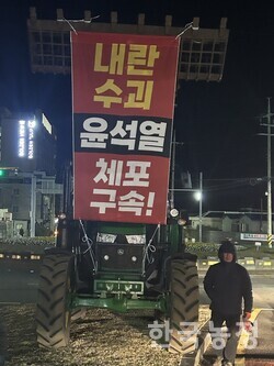 성산읍농민회가 윤석열 체포‧구속 현수막이 걸린 트랙터를 성산일출봉 입구 도로 중앙선 분리대에 세워 놓은 모습. 