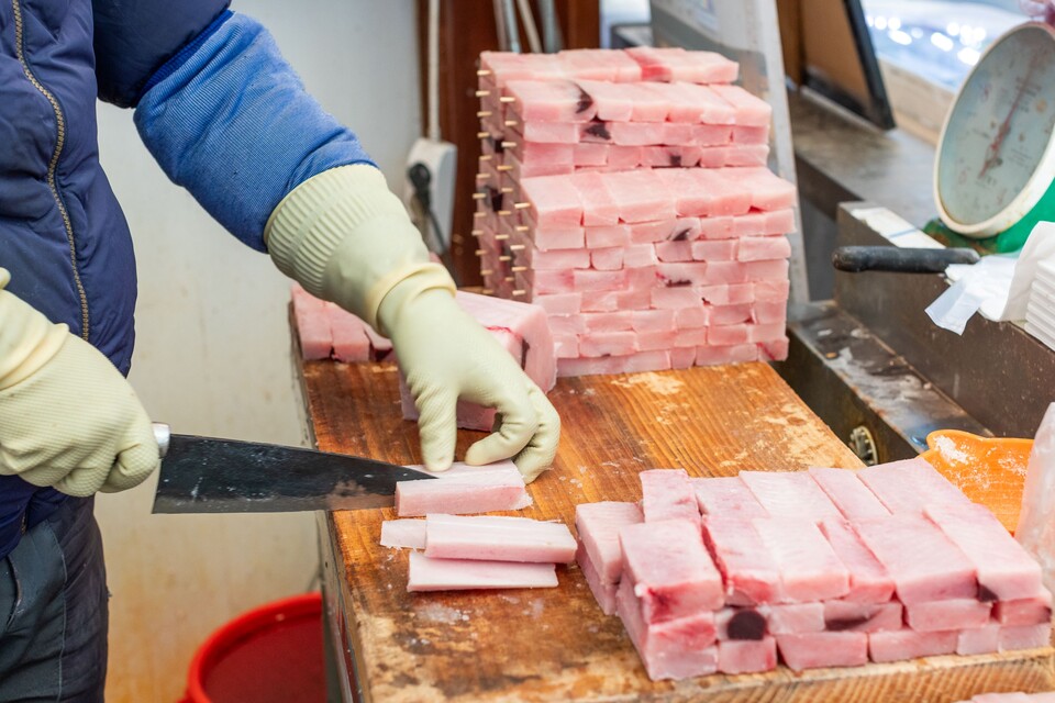 제물로 올릴 상어고기를 꼬지에 꿰는 작업을 하는 모습.