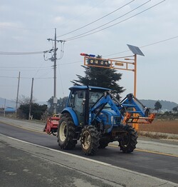 트랙터가 농업기계 주행 안내표지판(농기계 종류·접근 거리 등 정보 표시)이 설치된 도로를 달리고 있다. 농작업 재해 사망 사고 가운데 농기계 사고(54%)가 가장 많다. 농촌진흥청 제공