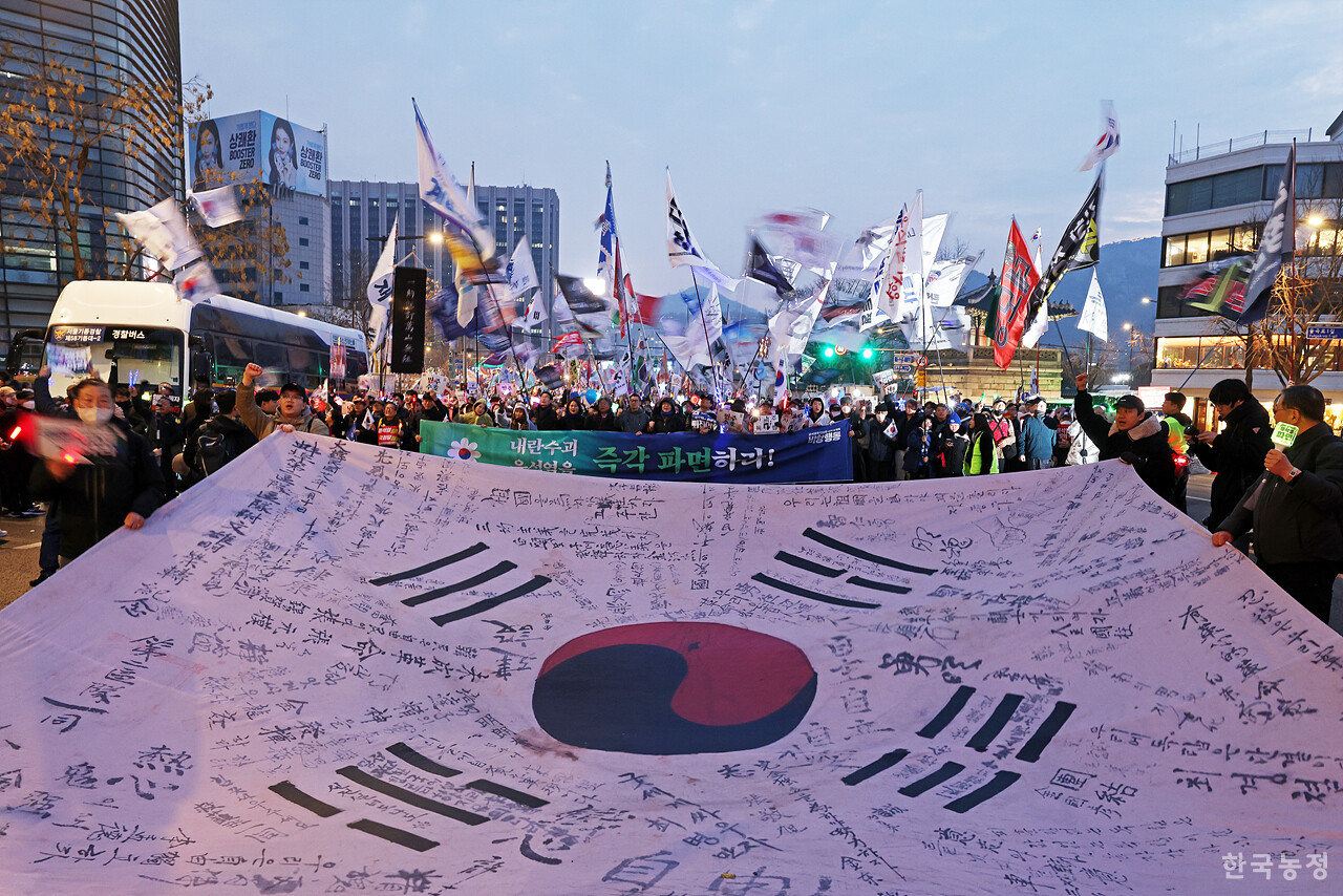범시민대행진을 마치고 행진을 시작한 시민들이 일본대사관 앞에서 대형 태극기를 펼친 채 일본의 역사 왜곡 행태를 규탄하고 있다.