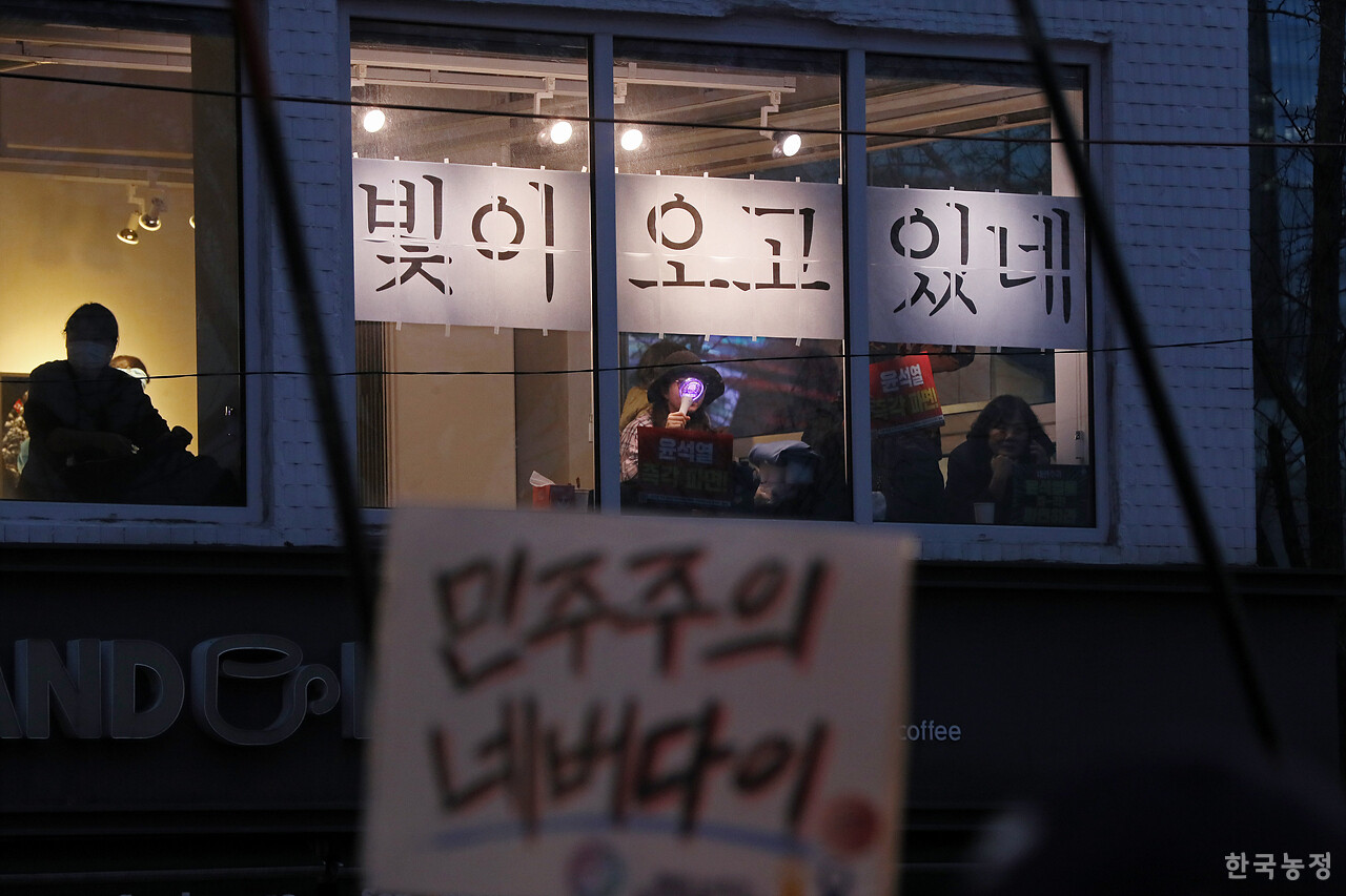 15일 오후 서울 광화문 동십자각 앞에서 '100만 시민 총집중의 날 윤석열 즉각 퇴진! 사회대개혁! 제15차 범시민대행진'이 열린 가운데 한 전시장에 '빛이 오고 있네'라는 문구가 붙어 있다. 한승호 기자