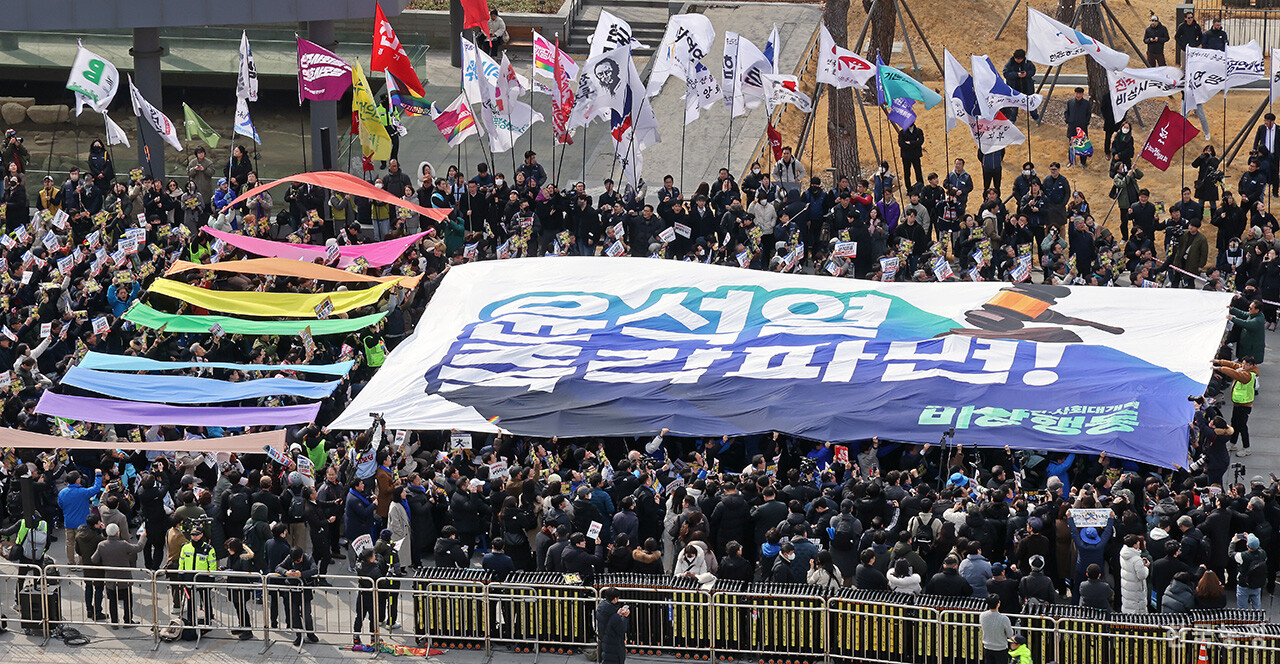 17일 오후 서울 광화문 북측 광장에서 열린 '윤석열 즉각 파면 촉구 각계 긴급시국선언 기자회견'에서 시민사회, 종교계, 정치권 인사 등 1500여명이 '윤석열 즉각 파면'이 적힌 대형 현수막을 펼치는 상징의식을 하고 있다. 한승호 기자