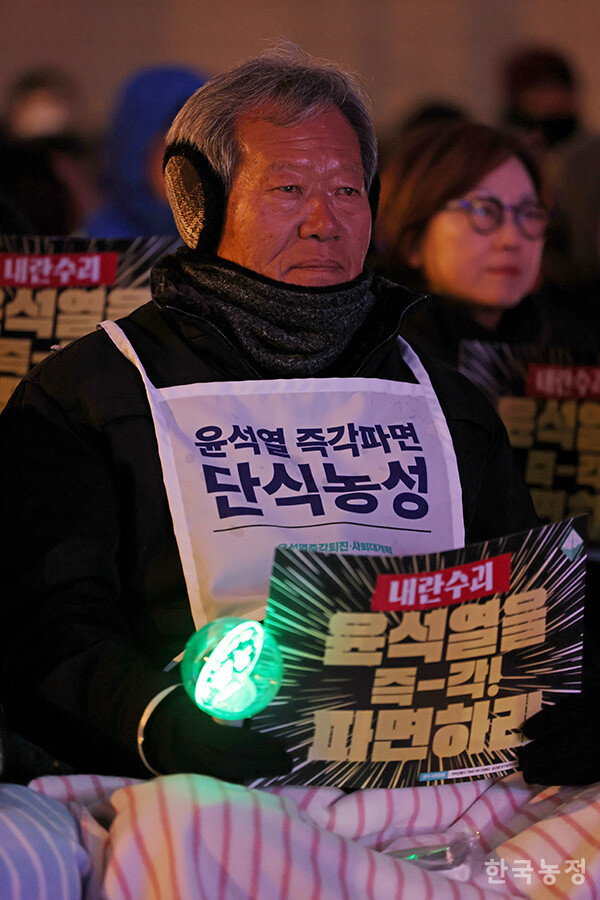 '윤석열 즉각 파면'을 촉구하며 단식농성 11일째를 보내고 있는 하원오 전국농민회총연맹 의장이 18일 저녁 서울 광화문 동십자각에서 열린 '내란수괴 윤석열 즉각 퇴진을 위한 2차 긴급집중행동'에 참석하고 있다. 한승호 기자