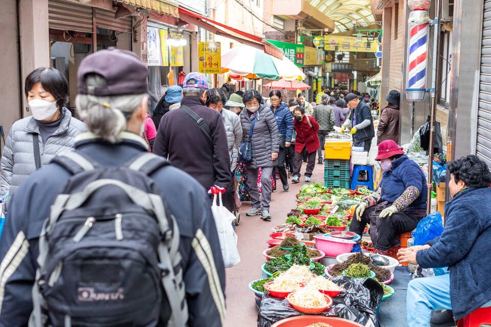 구포오일장에 찾아온 소비자들이 줄을 지어 좌판 옆을 지나가고 있다. 사진 류관희 작가