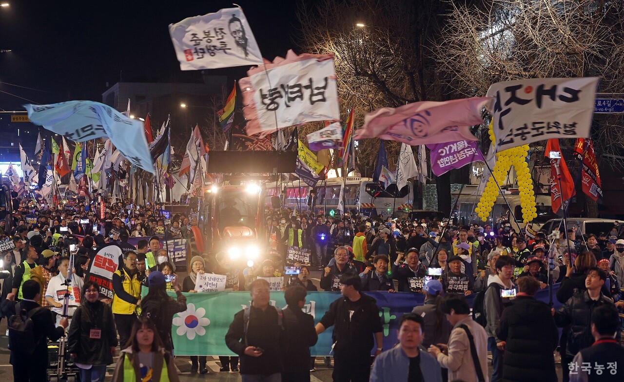 지난 26일 서울 경복궁역 인근에서 열린 ‘내란수괴 윤석열 즉각 파면 촉구 3차 긴급집중행동’에서 수많은 농민들과 시민들이 경찰이 불법 탈취한 트랙터를 되찾은 뒤 “우리가 이겼다”를 외치며 트랙터와 함께 거리를 행진하고 있다. 한승호 기자