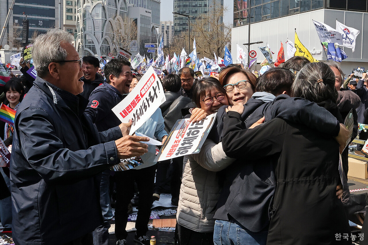 4일 오전 서울 종로구 헌법재판소 인근 안국역 앞에 모인 비상행동 공동의장단이 헌재가 윤석열 대통령에 대한 탄핵심판 선고에서 파면을 결정하자 부둥켜 안으며 기뻐하고 있다. 한승호 기자