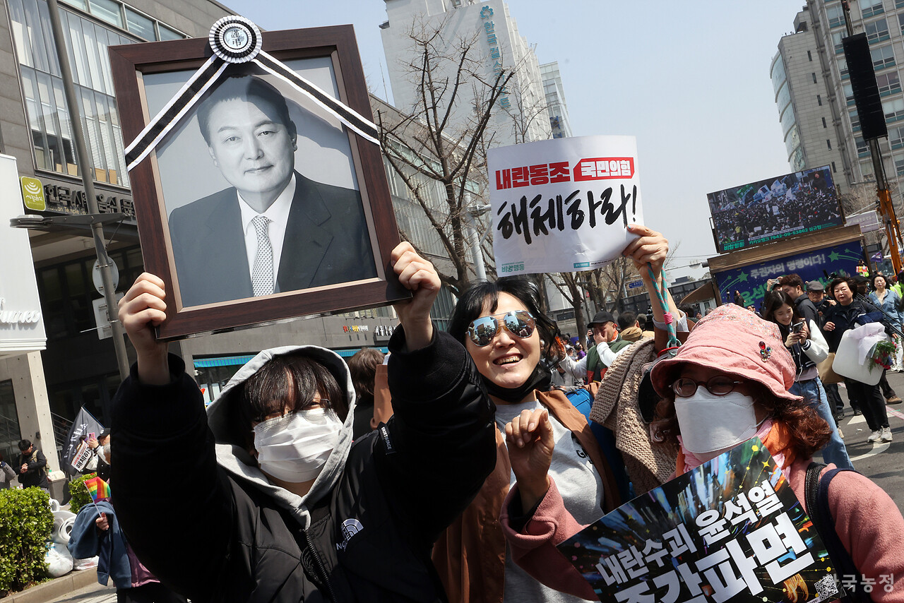 4일 오전 헌법재판소가 윤석열 대통령에 대한 탄핵심판 선고에서 파면을 결정하자 헌재 인근 안국역 앞에 모인 시민들이 근조 리본을 매단 윤석열 사진을 들고 기뻐하고 있다. 한승호 기자