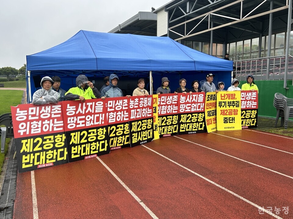 폭우가 쏟아지는 가운데 ‘제주 제2공항 강행저지 비상도민회의’ 회원들이 회의장 입구를 막고 있다.