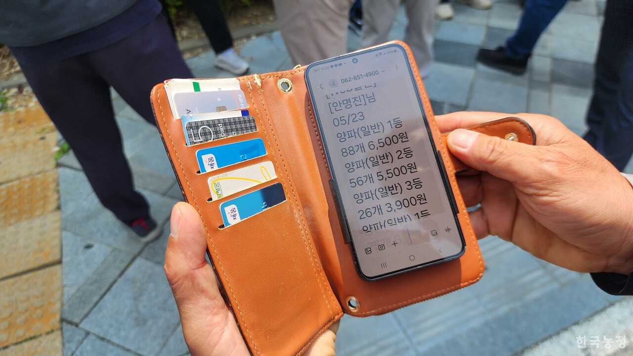 28일 정부세종청사 농림축산식품부 앞에서 열린 ‘양파 수급가이드라인 안정대 가격 1kg 750원 보장을 위한 전국양파생산자 대표 기자회견’ 이후 안명진 양파협회 함평군지회장이 1kg 6500원에 불과한 경매 결과를 보여주고 있다.