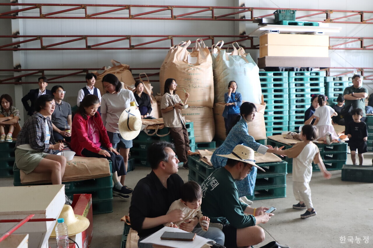 지난달 31일 경기도 연천군 군남면 임진여울영농조합법인의 벼 저장창고에서 농업먹거리청년모임 주최로 열린 2025 농업먹거리 청년 좌담회 ‘연결과 문화’ 참가자들이 도시쥐 정거장 실험 프로젝트 운영자 쥐프로씨의 이야기를 듣고 있다. 이날 좌담회는 '벼 저장창고'라는 농민들의 공간을 한껏 만끽할 수 있는 분위기 속에서 진행됐다.