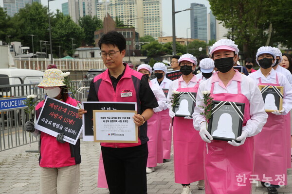 민태호 전국학교비정규직노동조합 위원장(가운데)을 비롯한 기자회견 참가자들이 폐암 산재 노동자의 영정과 국화를 들고 행진하고 있다.