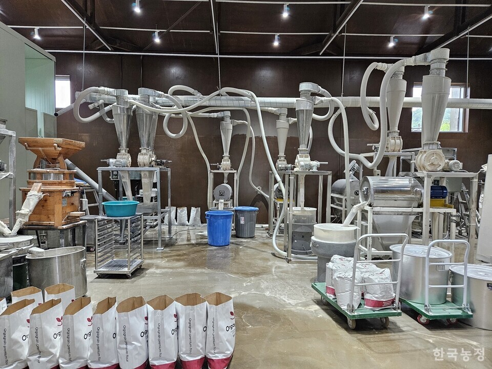 (주)오가그레인이 현재 양평군 단월면에서 농협창고를 빌려 운영 중인 제분소 내부 모습. (주)오가그레인은 현재 가동 중인 제분소(전통 맷돌방식)와 밀산업 밸리화 시범단지 조성 사업으로 인근에 마련될 예정이었던 제분소(기계식)를 함께 운영할 계획이었다. 