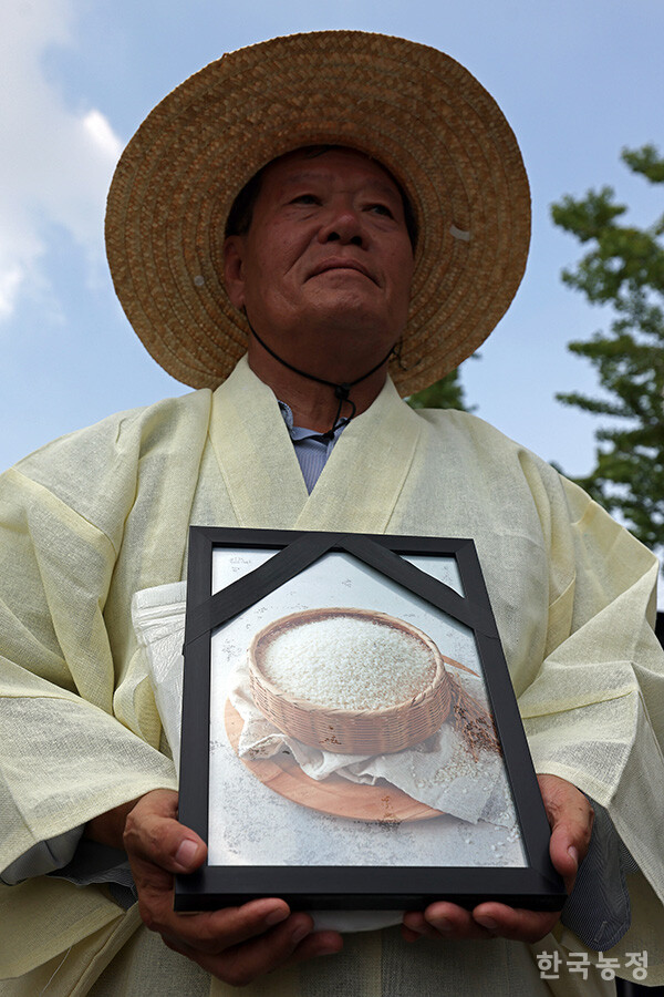 28일 오후 서울 용산 대통령실 앞에서 국민과함께하는농민의길·한국농축산연합회·한국종합농업단체협의회·축산관련단체협의회 공동 주최로 열린 ‘한-미 상호관세 협상 농축산물 개방 반대 전국농축산인 결의대회’에서 상복을 입은 하원오 농민의길 상임대표가 쌀의 영정사진을 들고 서 있다. 한승호 기자