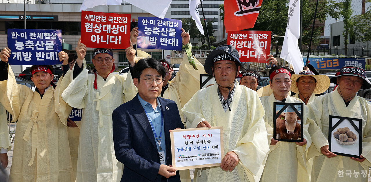 28일 오후 서울 용산 대통령실 앞에서 국민과함께하는농민의길·한국농축산연합회·한국종합농업단체협의회·축산관련단체협의회 공동 주최로 열린 ‘한-미 상호관세 협상 농축산물 개방 반대 전국농축산인 결의대회’에서 상복을 입은 농민단체 대표자들이 이영수 대통령실 농림축산비서관에게 '농축산물 개방 반대' 서한을 전달하고 있다. 한승호 기자