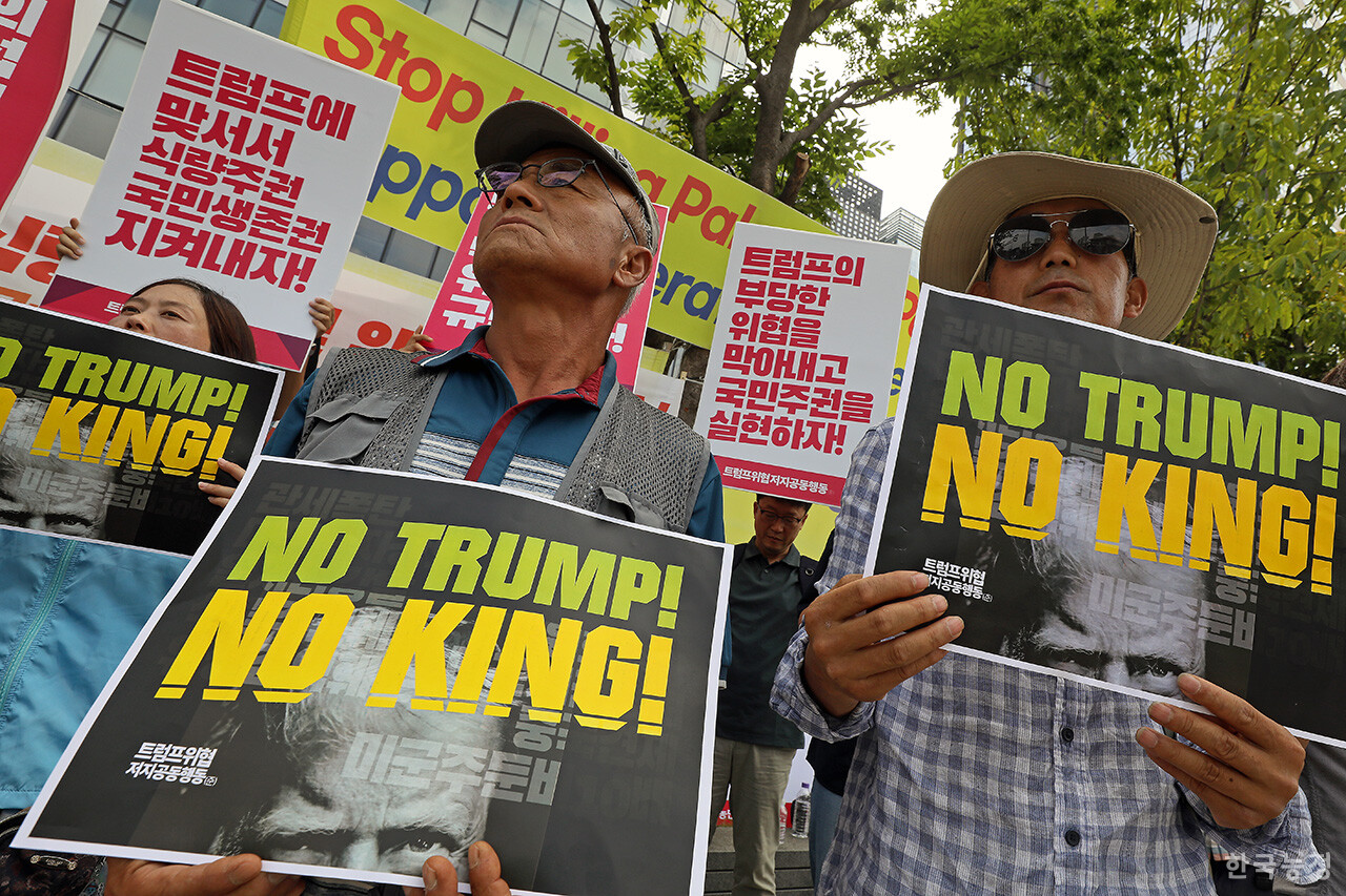 한미 관세협상 타결 소식이 전해진 31일 오전 서울 광화문 미대사관 옆 비상시국농성장에서 입장 발표 기자회견이 열린 가운데 농민들이 트럼프를 규탄하는 손팻말을 들고 서 있다. 한승호 기자