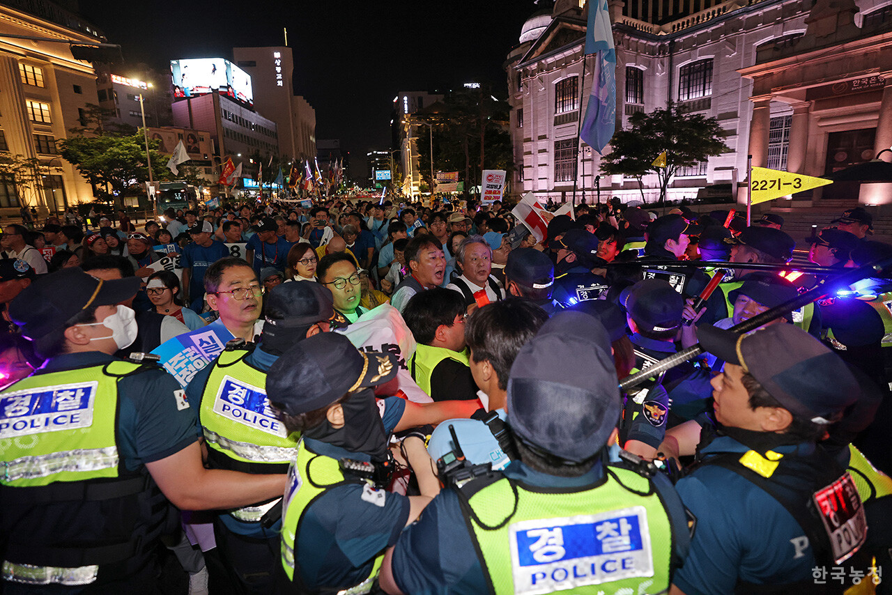 광복 80주년이었던 지난 15일 서울 숭례문 앞에서 열린 '광복 80년 평화 주권 역사정의 실현 8.15 범시민대회'에 참석한 농민, 노동자를 비롯한 수많은 시민들이 광화문 동십자각 방향으로 행진하던 중 경찰이 차량을 이용해 행진을 방해하자 한국은행 앞 도로에서 몸싸움을 벌이며 항의하고 있다. 한승호 기자