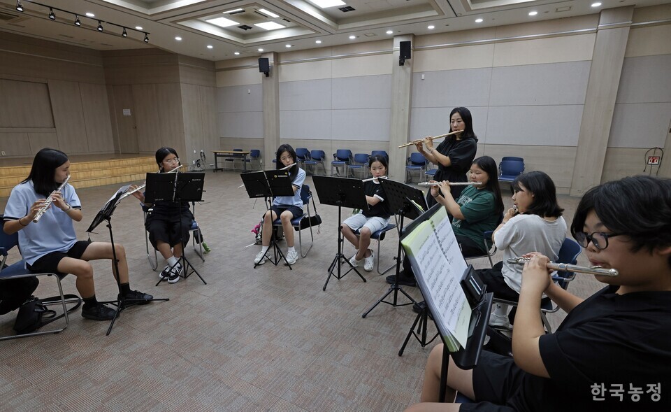 플룻을 배우는 아이들이 오케스트라 합주 연습에 앞서 이슬비씨의 플룻지도를 받고 있다.
