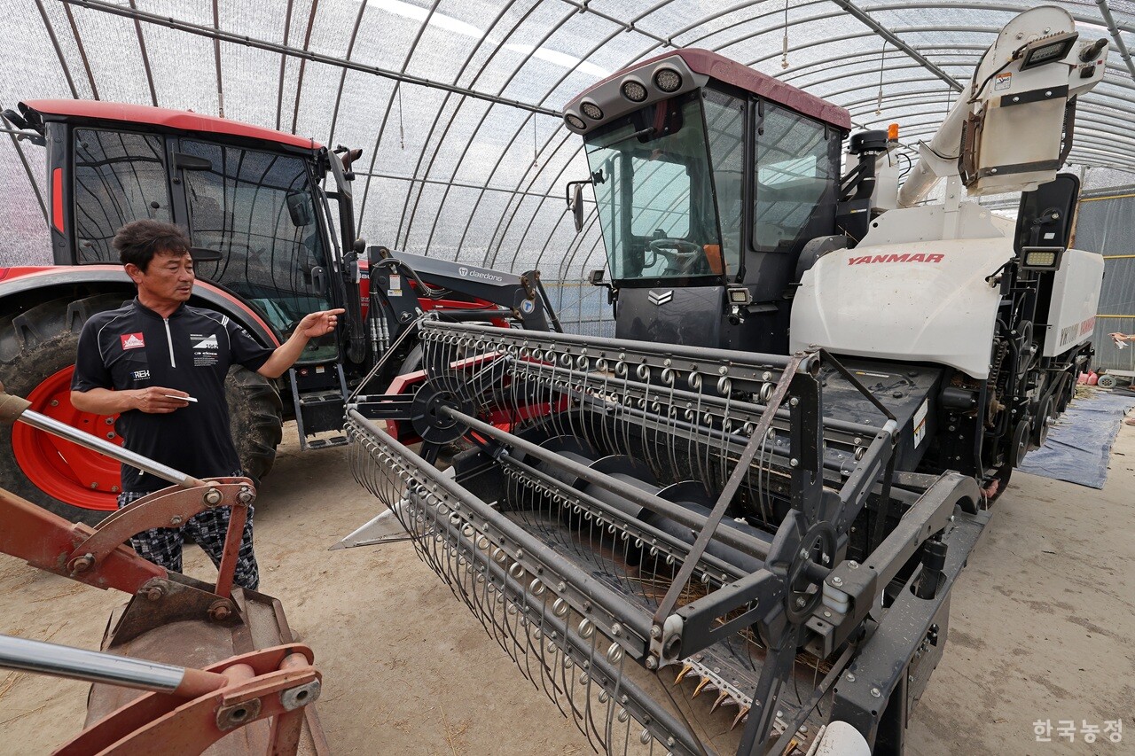 전북 김제시 부량면에서 농사짓는 최재호씨가 논콩으로 작목을 전환하며 구입한 1억원 대의 범용 콤바인을 가리키고 있다. 한승호 기자