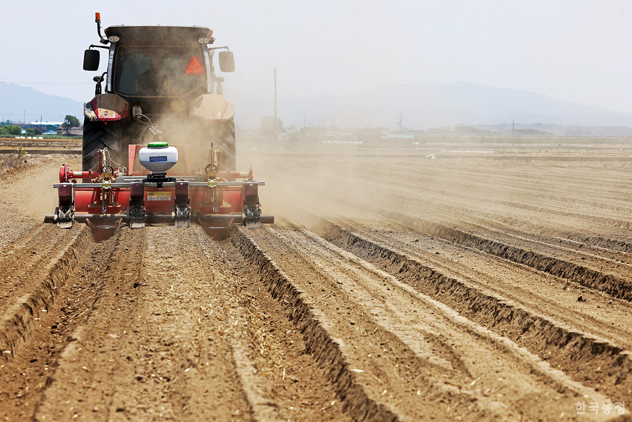 지난 6월 11일 전북 김제시 죽산면 신흥리 들녘에서 한 농민이 트랙터에 파종기를 연결해 콩을 심고 있다. 한승호 기자