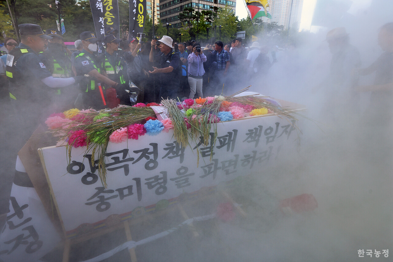 18일 오후 서울역 앞에서 열린 '수확기 쌀값 보장! 유통업자 말고 농민에게 쌀값을! 양곡정책 실패·내란농정 송미령 파면! CPTPP 가입 추진 중단! 9.18 전국농민대회'에서 용산 대통령실 인근까지 행진한 농민들이 상여를 부수는 상징의식 과정에서 경찰이 소화기를 살포하고 있다. 한승호 기자