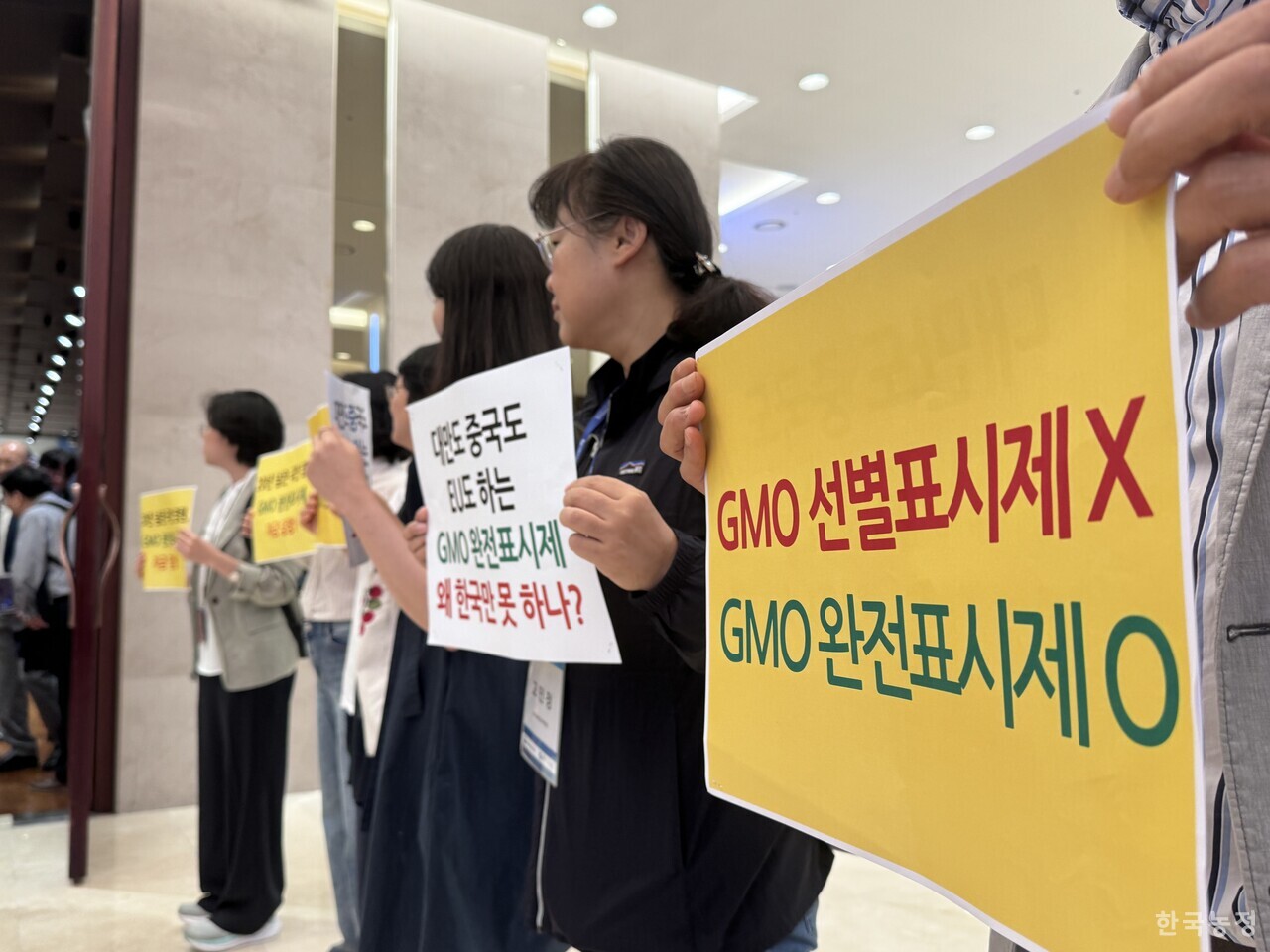 지난 19일 서울 중구 LW컨벤션센터에서 열린 ‘GMO 완전표시제 정책과 이슈 포럼’ 현장에서 원료 기반 GMO 완전표시제의 즉각 시행을 요구하는 소비자·시민사회단체의 피켓팅이 진행되고 있다.