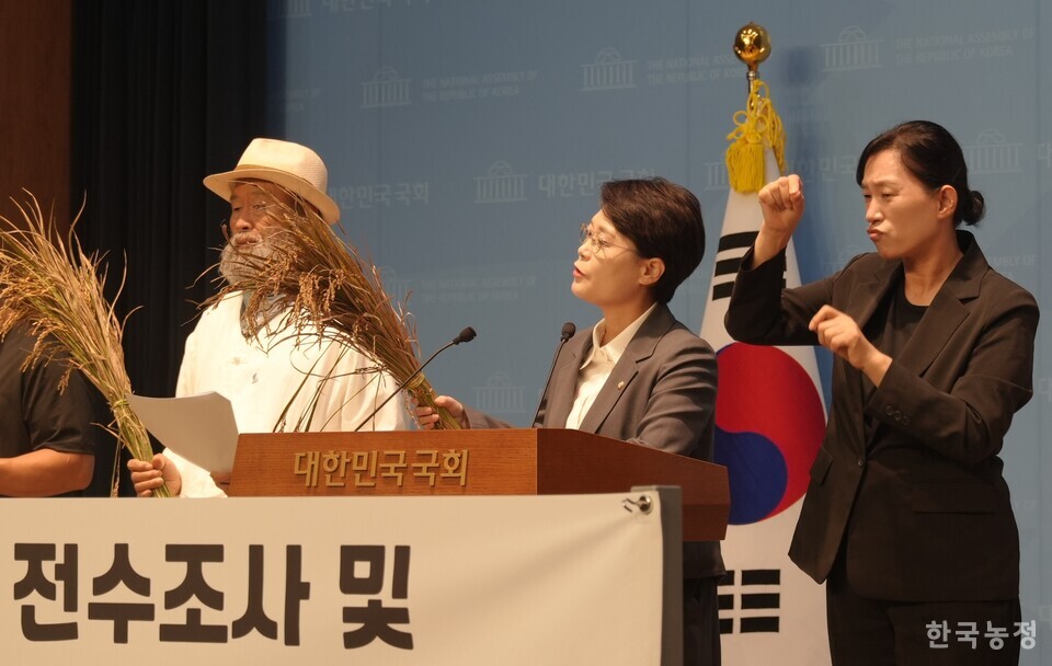 전종덕 의원이 농민들이 가져온 깨씨무늬 병이 든  벼를 들어보이며 피해 현황을 설명하고 있다.