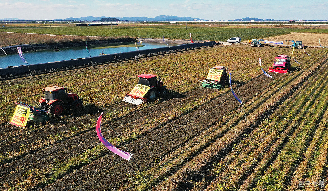 27일 오전 전북 김제시 부량면 들녘에서 열린 '논콩 피해 추가조사 실시! 특별재난지역 선포! 김제농민 논콩 갈아엎기 투쟁'에서 4대의 트랙터가 올가을 잦은 비로 수확이 불가능할 정도로 병이 발생한 논콩을 갈아엎고 있다. 한승호 기자