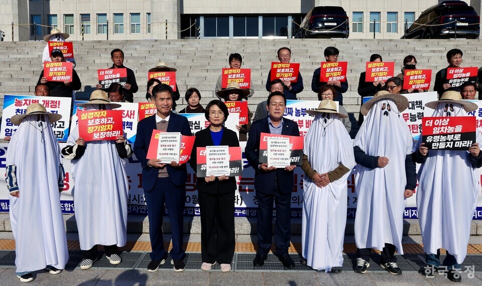 친환경 임차농 보호 대책 마련 및 제도 개선 촉구 기자회견에서 ‘유령농부’들이 국회 농림축산식품해양수산위원회 소속 이원택 더불어민주당 의원(왼쪽), 임미애 더불어민주당 의원(가운데), 김선교 국민의힘 의원(오른쪽)에게 1만4000여명의 서명이 담긴 책자를 전달했다. 한승호 기자