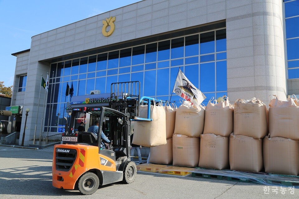 지게차로 나락을 쌓고 있는 농민회원.