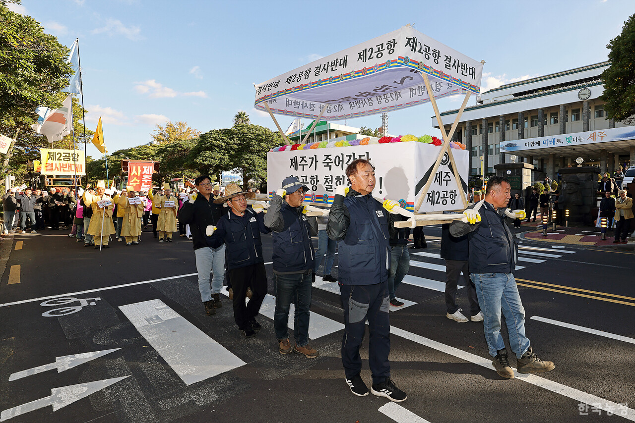 제주 제2공항 반대투쟁 10년을 맞아 지난 10일 제주도청 앞에서 열린 제주농민대회에서 농민들이 '제주가 죽어간다 제2공항 철회하라' 등이 적힌 상여를 메고 도청 앞을 행진하고 있다. 한승호 기자