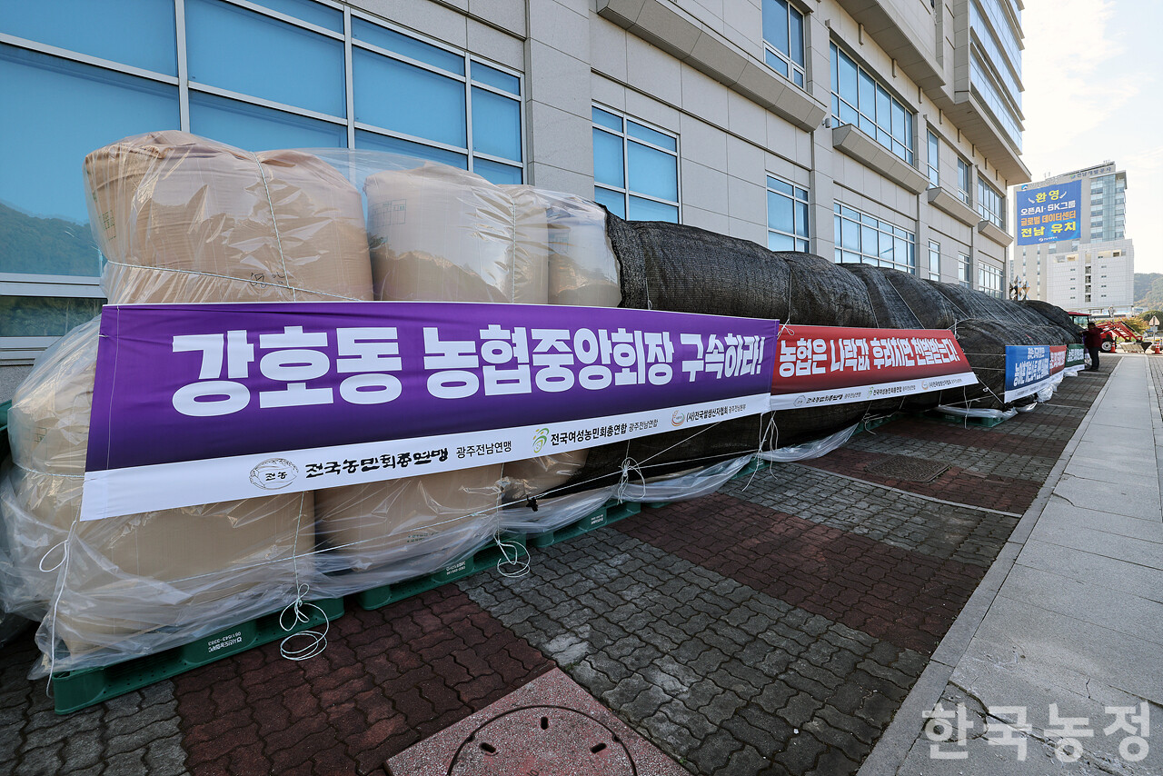 지난 14일 전남 무안군 농협중앙회 전남본부 앞에서 '나락값 8만원 보장 광주전남 농민대회'가 열린 가운데 농민들이 지역 곳곳에서 가져온 나락을 농협 앞에 쌓은 뒤 요구사항이 적힌 현수막을 매달고 있다. 한승호 기자