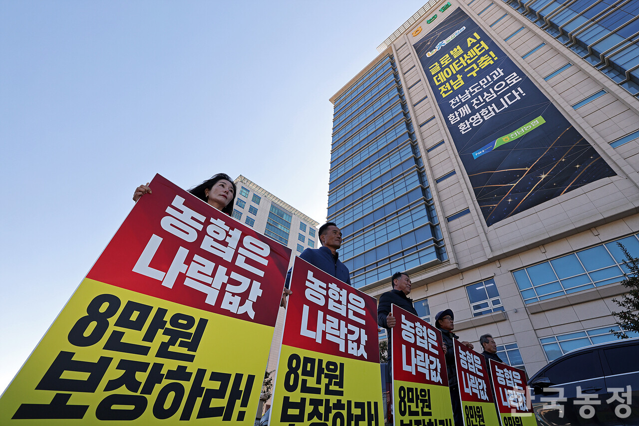 지난 14일 전남 무안군 농협중앙회 전남본부 앞에서 '나락값 8만원 보장 광주전남 농민대회'가 열린 가운데 농민들이 '농협은 나락값 8만원 보장하라'가 적힌 손팻말을 들고 서 있다. 한승호 기자