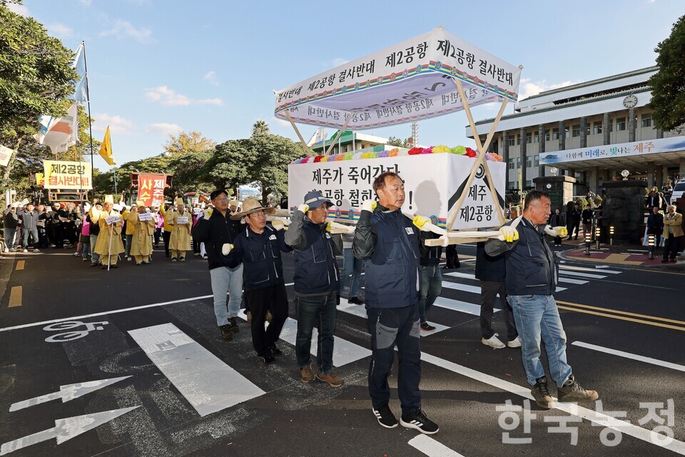 제주 제2공항 반대투쟁 10년을 맞아 지난 10일 제주도청 앞에서 열린 제주농민대회에서 농민들이 제2공항 건설에 맞서 끝까지 싸울 것을 선언한 뒤 ‘제주가 죽어간다 제2공항 철회하라’ 등이 적힌 상여를 메고 도청 앞을 행진하고 있다. 한승호 기자