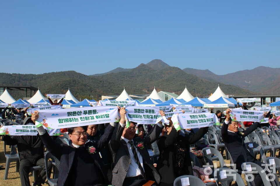 지난 14일 경남 밀양시에서 제13회 경상남도 친환경농업인대회가 열린 가운데 참가자들이 ‘맑은산 푸른들, 함께하는 친환경 아리랑’이라는 슬로건이 적힌 수건을 들어 보이고 있다.