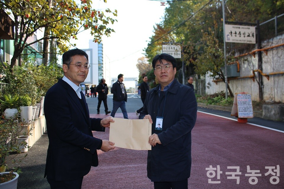 이석하 진보당 영광지역위원장(왼쪽)이 이영수 대통령실 농림축산비서관에게 농어촌기본소득 관련 요구사항을 전달하고 있다.