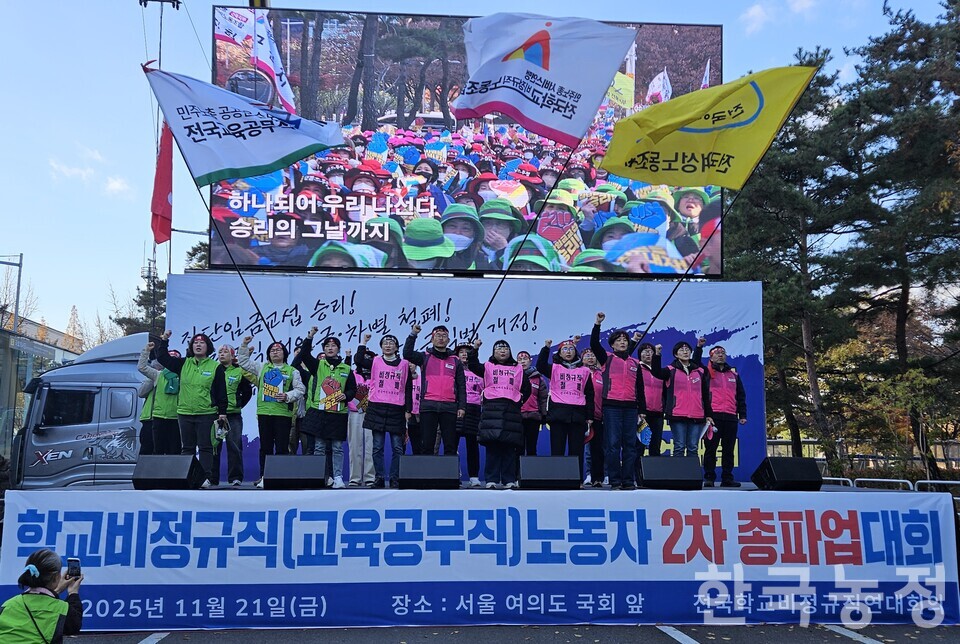 지난 21일 서울 영등포구 국회의사당 인근에서 전국학교비정규직연대회의의 광주·전남·전북·제주지역 조합원들이 파업대회를 연 가운데, 지부장 등 대표자들이 단상 위에 올라 파업가를 제창하고 있다.