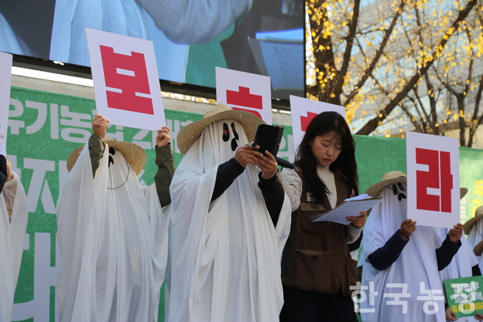 22일 서울 중구 숭례문 앞에서 열린 친환경 생산자-소비자 결의대회에서 유령 탈을 쓴 친환경이 발언하고 있다.