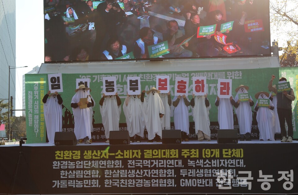 22일 서울 중구 숭례문 앞에서 열린 친환경 생산자-소비자 결의대회에서 유령 탈을 쓴 친환경 임차농들이 ‘임차 농부 보호하라’라는 글자가 쓰인 플래카드를 들고 서있다.