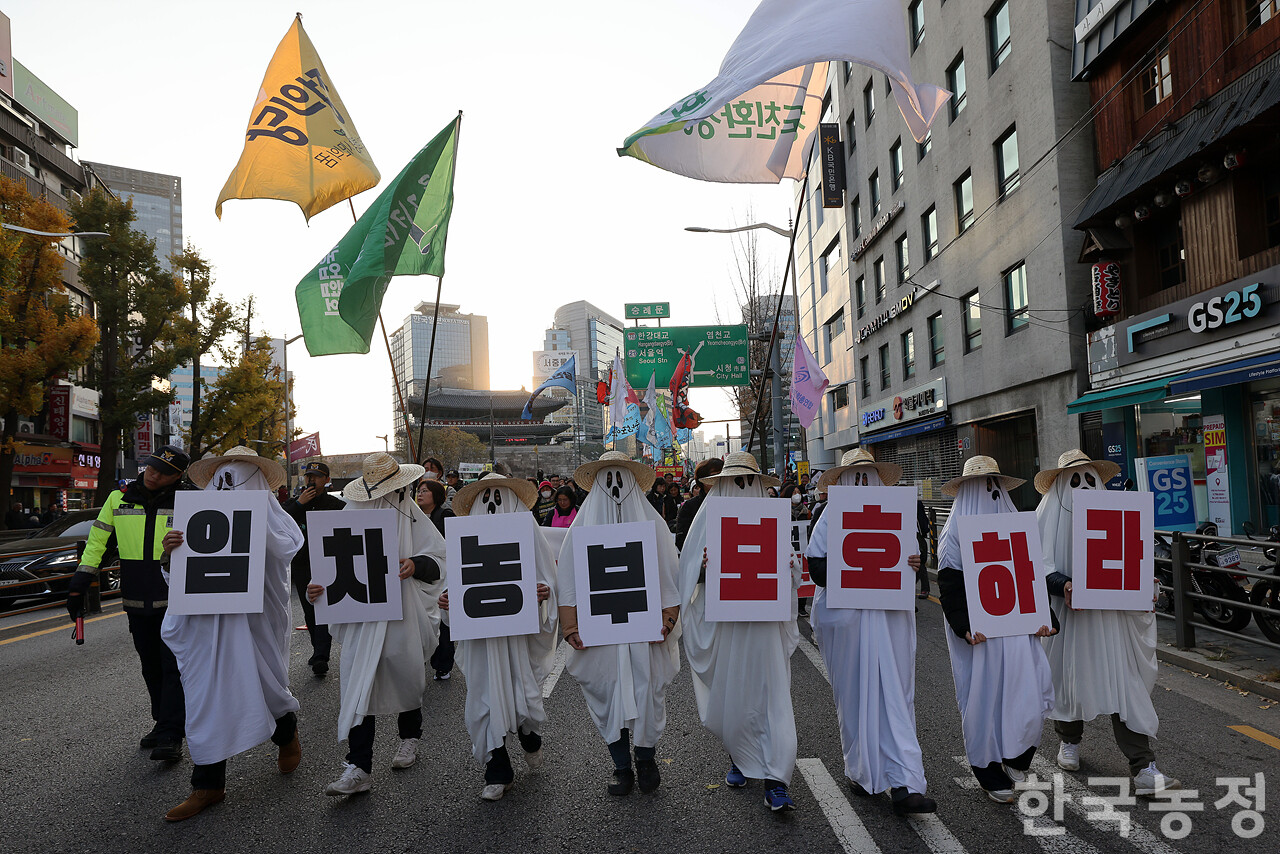 22일 오후 서울 숭례문 앞에서 열린 ‘기후재난 근본대책 수립! 농정대전환 실현! 2025 전국농민대회’에서 친환경농민들이 농지 소유주와 친환경인증으로 인한 갈등으로 농지를 빼앗길 수밖에 없는 처지를 빗대 '임차농부 보호하라' 문구를 들고 행진하고 있다. 한승호 기자