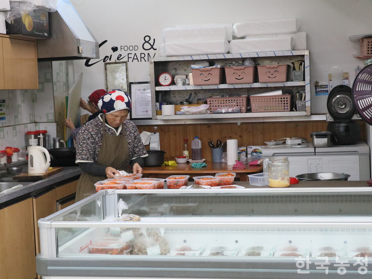 지난 11일 충남 홍성군 홍동농협 하나로마트 한 켠의 반찬 매장에서 할머니먹거리협동조합 회원이 통에 반찬을 담고 있다.