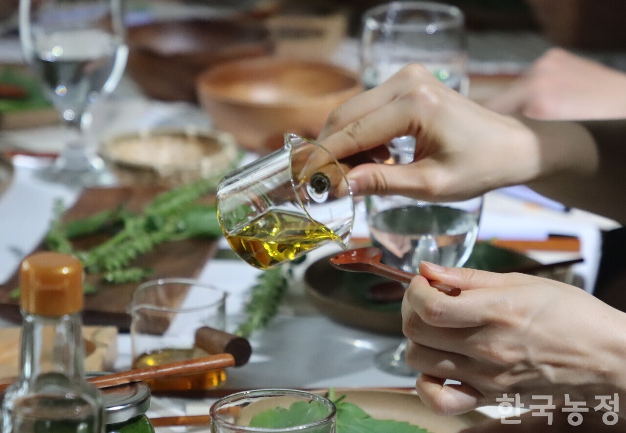 지난 9월 20일 서울 마포구 ‘레인보우큐브'에서 식문화 플랫폼 벗밭이 개최한 미식 워크숍 ‘들깨의 맛, 공동의 기억' 중 한 참가자가 농업회사법인 내포에서 토종 들깨로 만든 들기름을 숟가락에 붓고 있다. 내포가 충남 예산 농민들로부터 수매한 들깨·참깨로 만들어낸 전통기름 제품군은 ‘매헌생명창고’란 브랜드명 아래, 지속가능한 식생활을 추구하는 시민들의 식탁에 오른다.