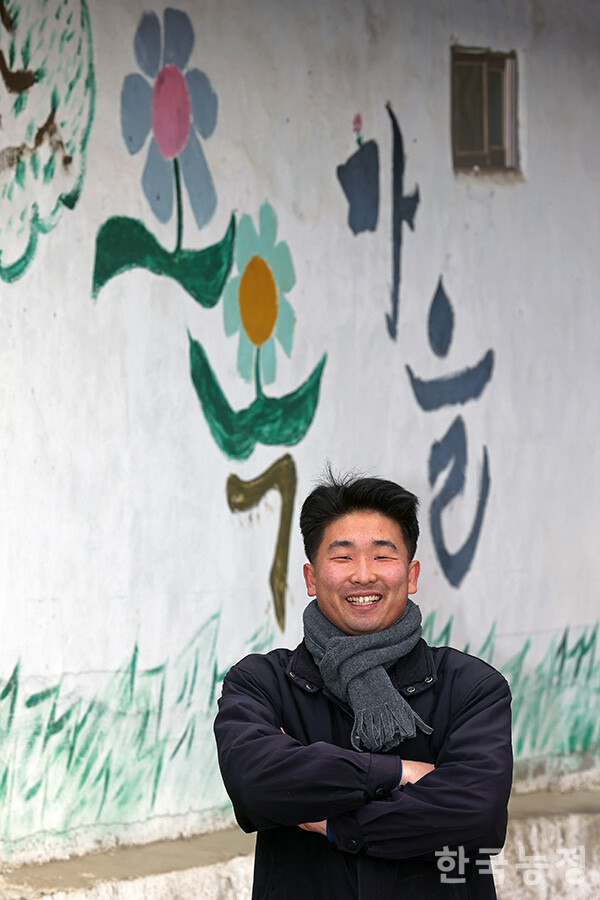 정민수 전북 장수군 오옥·월천·옥자동 마을 이장이 지난달 23일 본지와의 인터뷰를 앞두고 오옥마을 입구 벽화 앞에서 의기양양한 자세를 취하고 있다. 정 이장은 “앞으로도 마을에 대한 욕심만 부릴 것”이라면서도 “‘농림축산식품부 홍보대사’가 꿈이라는 이야기는 꼭 써달라”고 웃으며 당부했다. 한승호 기자
