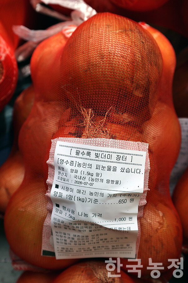 7일 오후 국민과함께하는농민의길 주최로 서울 종로구 동화면세점 앞에서 ‘농자재값 폭등! 농산물 가격 폭락! 근본대책 촉구 7·7 전국농민대회’가 열린 가운데 사전행사로 진행된 '팔수록 빚더미 장터'에서 농민들이 가져온 양파 1.5kg 망을 1000원에 판매하고 있다.&nbsp;
