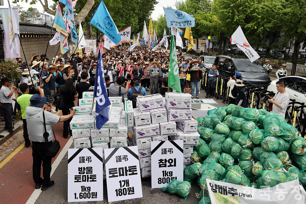 7일 오후 국민과함께하는농민의길 주최로 서울 종로구 동화면세점 앞에서 열린 ‘농자재값 폭등! 농산물 가격 폭락! 근본대책 촉구 7·7 전국농민대회’에 참석한 농민들이 청와대 분수대 앞까지 행진한 가운데 양파, 오이, 애호박, 가지 등을 거리에 쌓은 뒤 대책 마련을 거듭 촉구하고 있다.