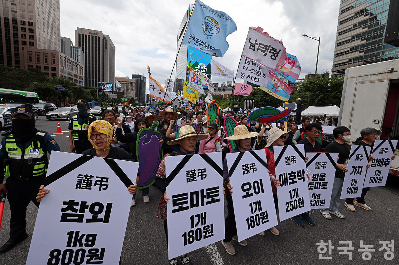 7일 오후 국민과함께하는농민의길 주최로 서울 종로구 동화면세점 앞에서 열린 ‘농자재값 폭등! 농산물 가격 폭락! 근본대책 촉구 7·7 전국농민대회’에서 전국에서 모인 농민들이 최근 헐값을 기록중인 각 농산물의 가격이 적힌 손팻말을 앞세우고 청와대 앞으로 행진하고 있다. 한승호 기자