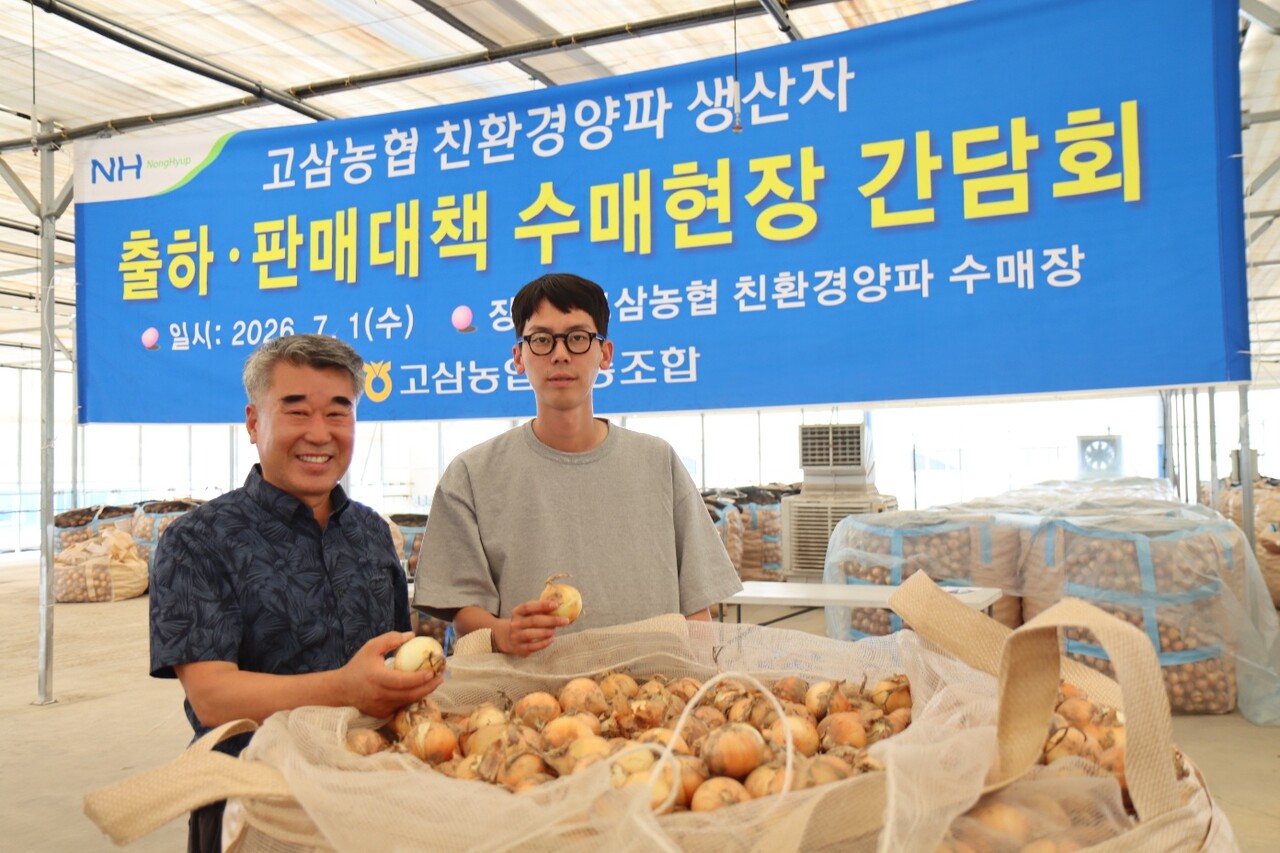 지난 1일 고삼농협 친환경 양파 수매 현장에서 윤홍선 고삼농협 조합장(왼쪽) 등이 양파를 들어 보이고 있다. 고삼농협 제공