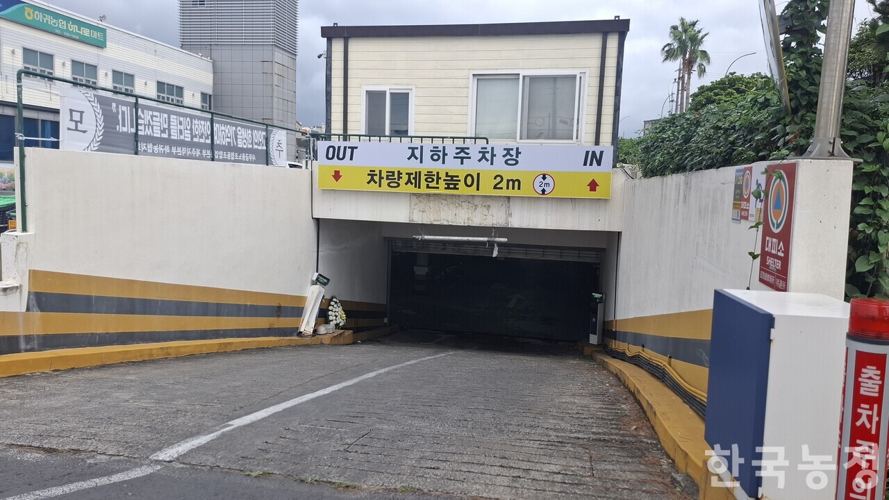 제주도 제주시 애월읍 하귀농협 하나로마트 지하 주차장으로 내려가는 길. 고 김영균씨는 이곳에서 당한 지게차 전도사고로 목숨을 잃었다. 내리막길 왼쪽에 김씨를 추모하기 위해 놓인 화환이 자그마하게 보인다.